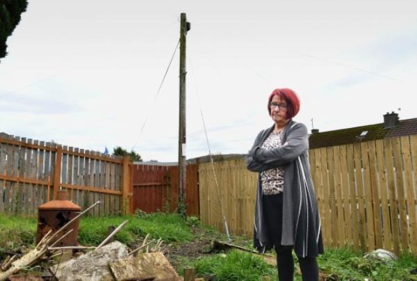 Ellen Ballantyne with the mast in her back garden. Photo release November 10 2023. See SWNS story SWLSmast. A pensio<em></em>ner has been hit with ?1,000 bill to have a telecom company's mast wires moved in her garden. Ellen Ballantyne, 67, wants to lay decking and have an outdoor seating area at her home. But broadband provider Openreach say she'll have to stump up to get it the way she wants. A mast and 'stay wire' have been prominent 'features' in resident Ellen's garden for more than 20 years.