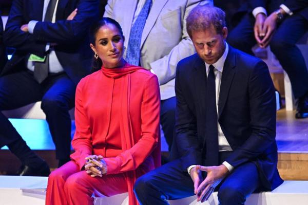 Meghan, Duchess of Sussex and Britain's Prince Harry, Duke of Sussex, react as they attend the annual One Young World Summit at Bridgewater Hall in Manchester.