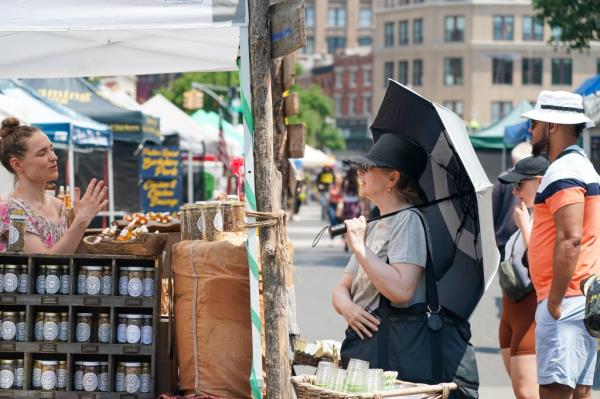 A woman holds an umbrella to shield her from the sun. 